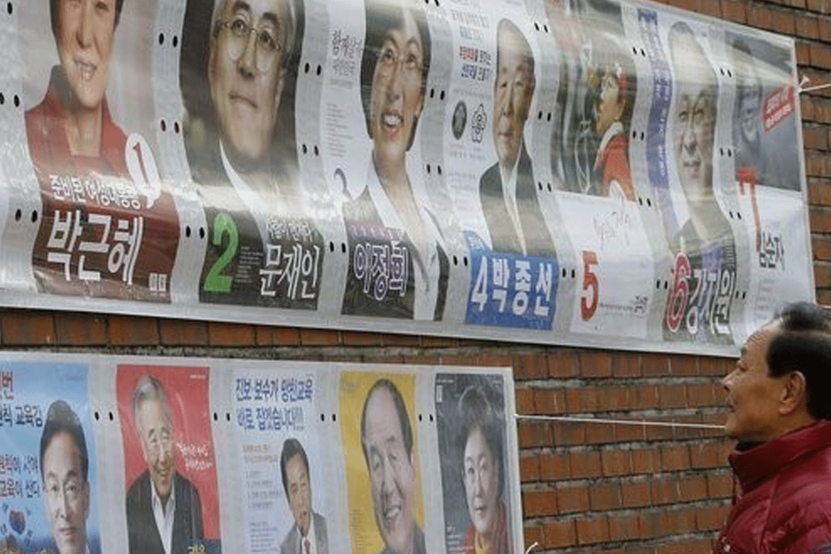 South Korean election posters displayed on a street wall, showcasing various candidates and electoral pivotal moments.