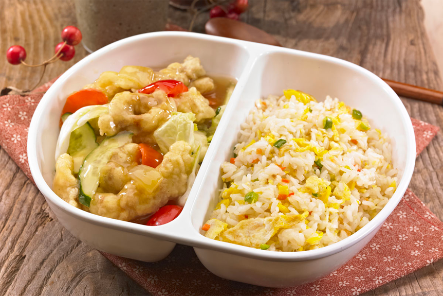 半份糖醋肉加炒飯，餐盒一側金黃香酥的糖醋肉，另一側是炒得恰到好處的黃色炒飯，提供視覺上和味覺上的雙重享受。