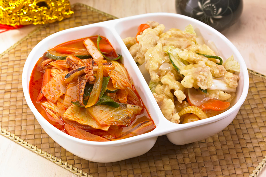 韓式糖醋肉搭配辣海鮮麵，套在雙格餐盒中，提供味蕾多彩的刺激和享受，無論是酥炸的甜味還是香辣的海鮮湯頭，均在此呈現。