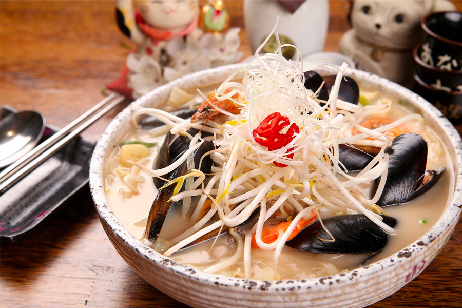 一碗韓式白湯炒碼麵，看上去有白色富含海鮮的湯底，並鋪滿豆芽等新鮮蔬菜，呈現清淡爽口的感覺，非常適合不嗜辣的食客。