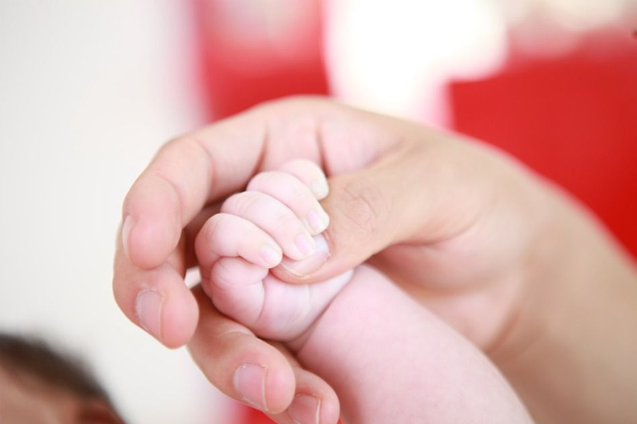 Pregnant woman holding her belly, symbolizing concerns about low birth rates in South Korea.