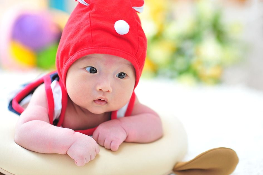 A hand holding a newborn's hand, highlighting the challenges of nurturing children in South Korea.