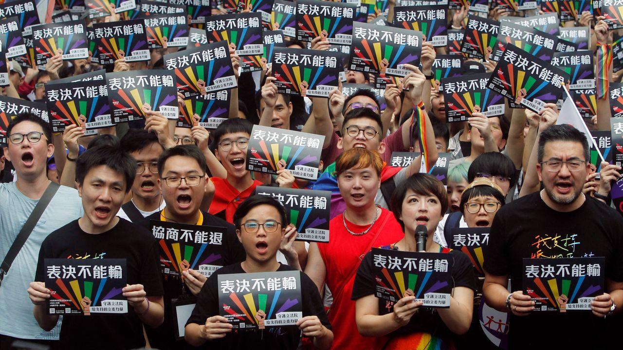 多人在台灣的抗議活動中舉起支持彩虹旗的牌子，展示團結的力量。