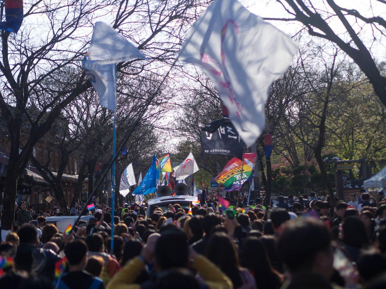 鬧區中的抗議示威活動，彩虹旗在眾多抗議標語中顯得醒目。
