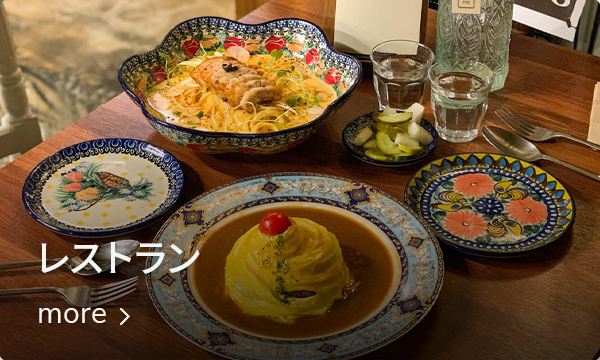 広々としたレストランでの韓国風オムライス、スープ、サイドディッシュが並ぶテーブルの写真