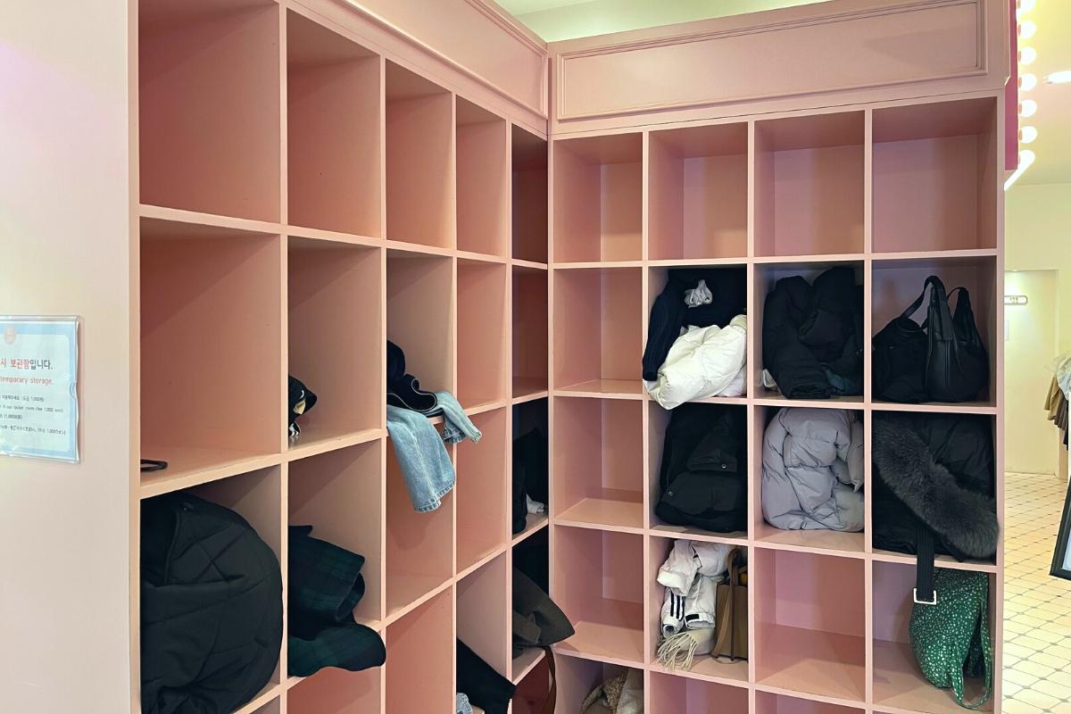 Photo of neon signs and detailed size charts in Korean inside the Ehwa School Uniform shop, adding to the vibrant and informative atmosphere.