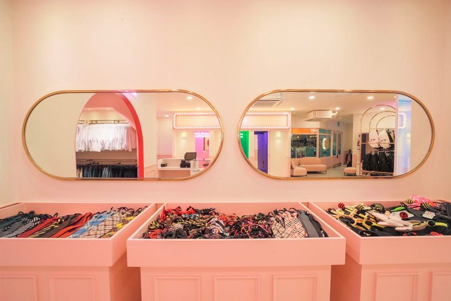 Interior view of the Ewha School Uniform rental shop with pink decorations and mirrors, showcasing a variety of colorful accessories in Seoul.