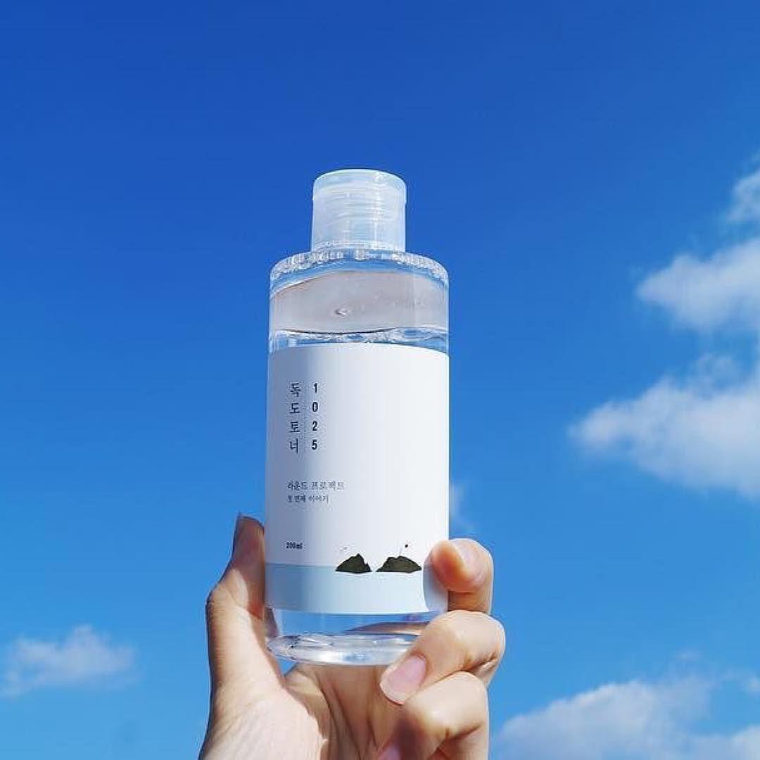 Round Lab 1025 小偷化妆水，平衡夏季肌肤，放置在蓝天背景下展示其清澈纯净的效果。