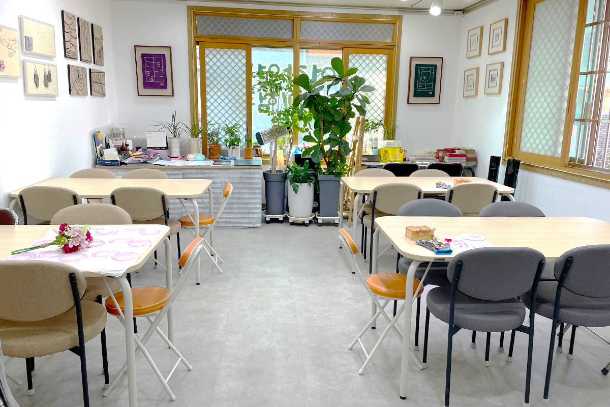 Inside the Insadong K-Art Center with tables and chairs arranged for seal engraving workshops, providing a comfortable environment for visitors.