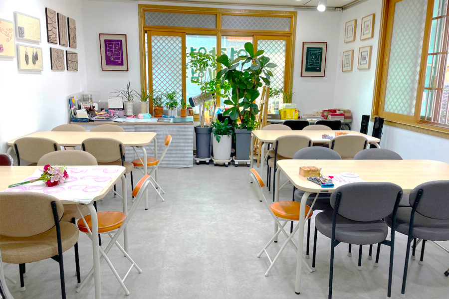 Interior view of a craft room at Insadong's K-Art Center with tables and plants.