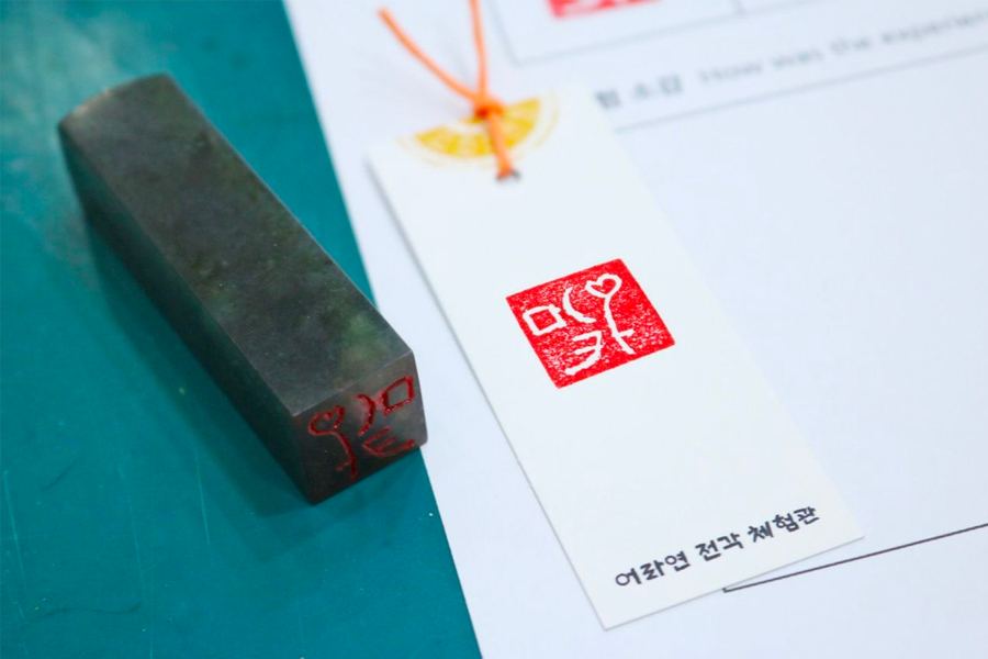 A close-up of a personalized stone stamp with an engraved Korean design at Insadong K-Art Center.