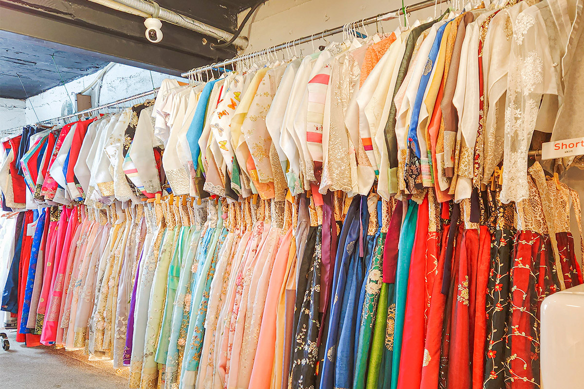 Một hàng dài với nhiều hanbok truyền thống đầy màu sắc được treo bên trong cửa hàng tại Ipgo Gage, Busan, Hàn Quốc.