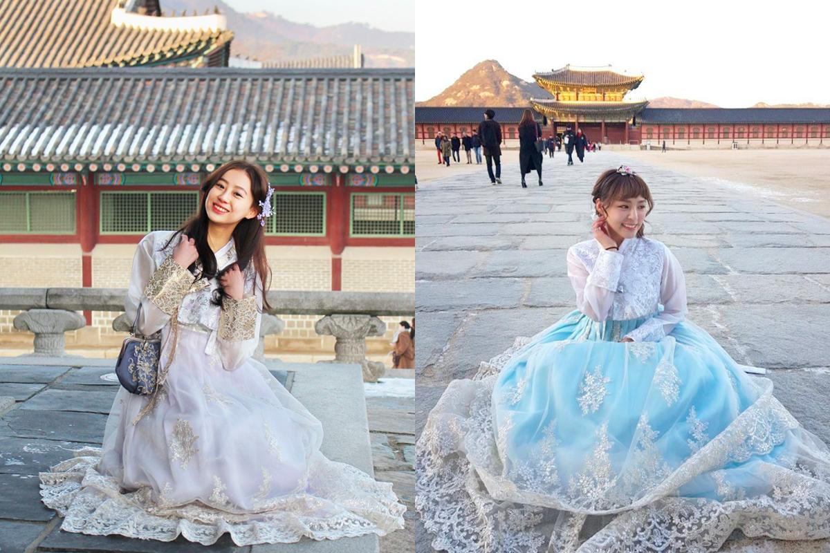 身穿藍色韓服的女子站在韓服租借店裡，展示韓服華麗設計的細節。」