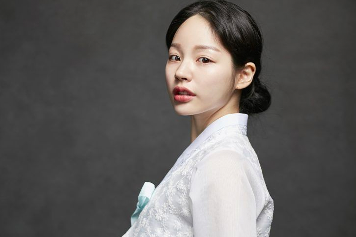 展示一名穿著簡約藍色韓服的女子，展示韓服的優雅設計和細節。」