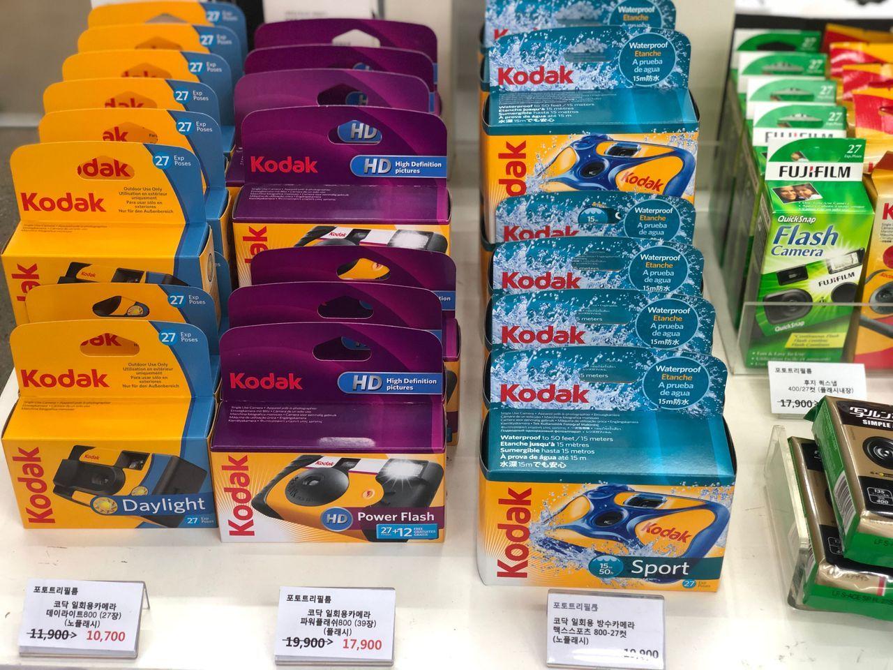 Variety of Kodak disposable cameras displayed with colorful packaging.