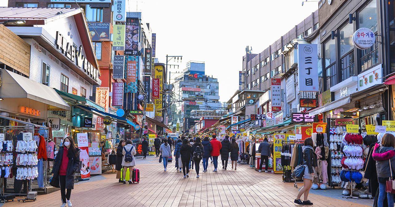 Vibrant street market in Korea filled with various shops and people.