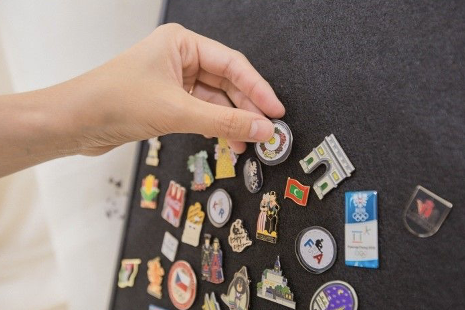 裝飾著多款徽章的佈告板，象徵旅行回憶