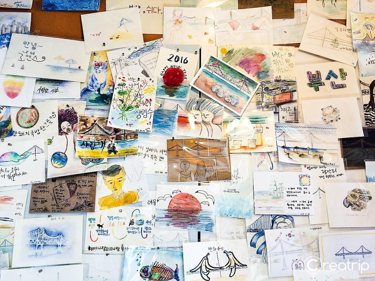 A creative display of colorful postcards pinned to a bulletin board showing messages and memories.