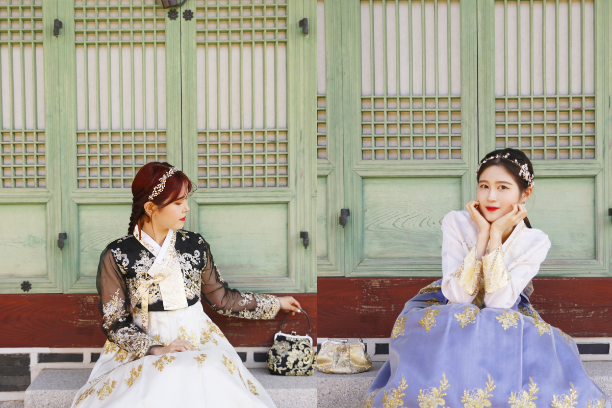 A young woman posing elegantly in a graceful hanbok, outdoors in Korea's traditional scenery.