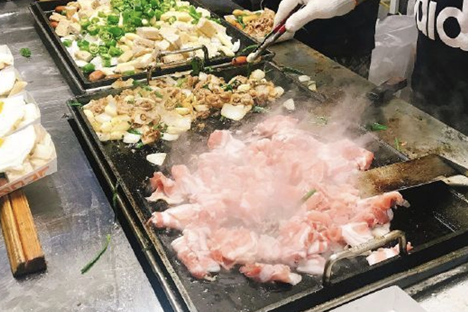 韓國夜市中正在烹調的多種食材，展現韓國夜市的小吃製作過程和活力。