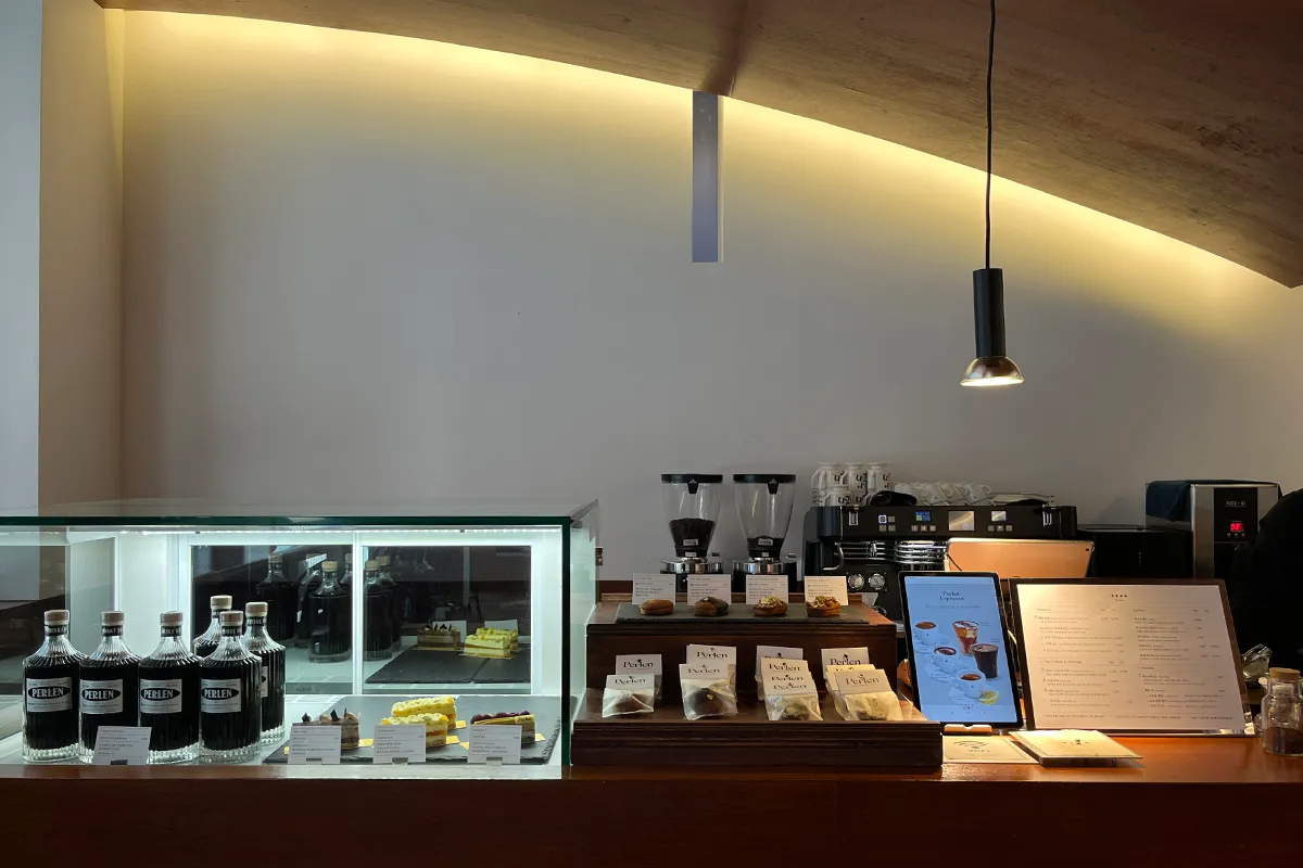 Perlen Yeonnam’s cafe counter in Seoul, offering vegan-friendly drinks and desserts in an aesthetic modern setting.