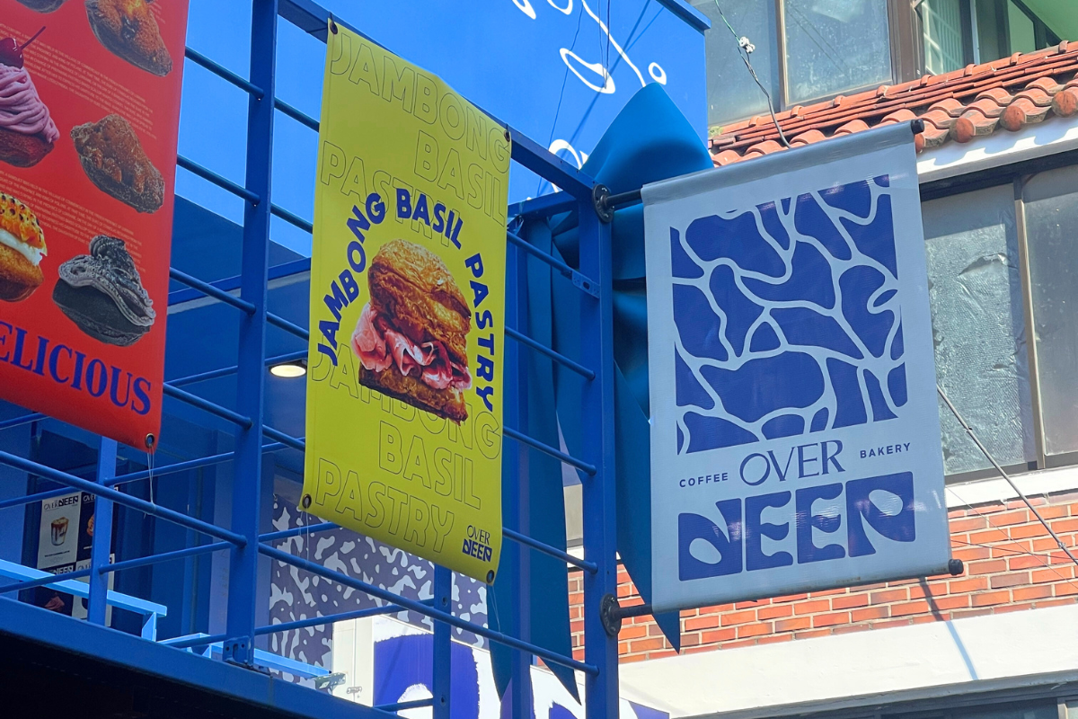 Colorful signage of OVERDEEP cafe in Yeonnam-dong, showcasing their slogan and unique pastry offerings.