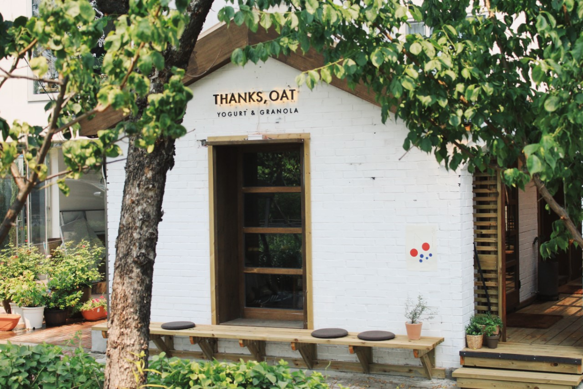 Thanks, Oat cafe exterior in Yeonnam-dong, known for its cozy wooden design surrounded by greenery.