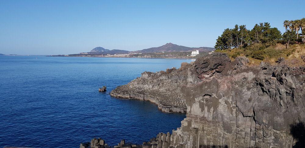 濟州島的柱狀節理與遼闊海景，這片天然形成的玄武岩石柱是濟州島地質奇觀之一，吸引遊客駐足觀賞