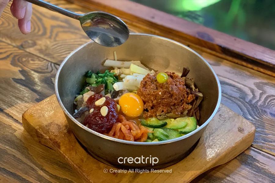 摆满丰富配料的全州拌饭，色泽鲜艳且材质各异，展示了全州必吃美食的独特魅力。