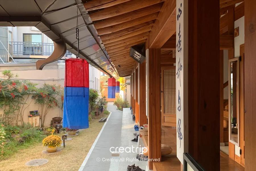 全州韩屋住宿区的庭院景观，色泽鲜艳的传统灯笼沿着走道装饰，展现了韩屋建筑的独有特色。