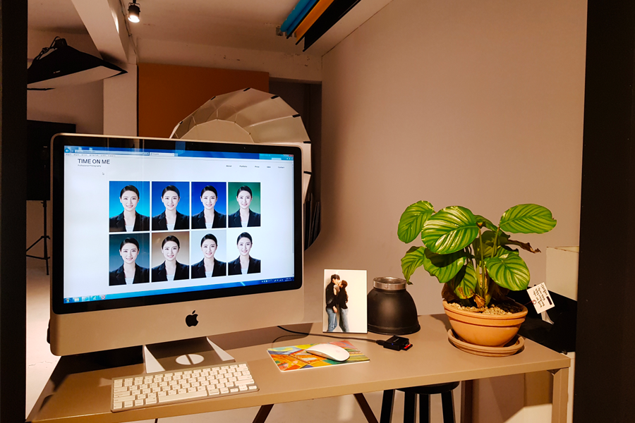 Editing station at Time On Me Studio displaying photo selections on a computer, alongside decorative elements.