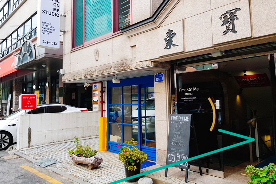 Exterior view of Time On Me Studio in Hongdae, Seoul, showcasing the building entrance and signage.