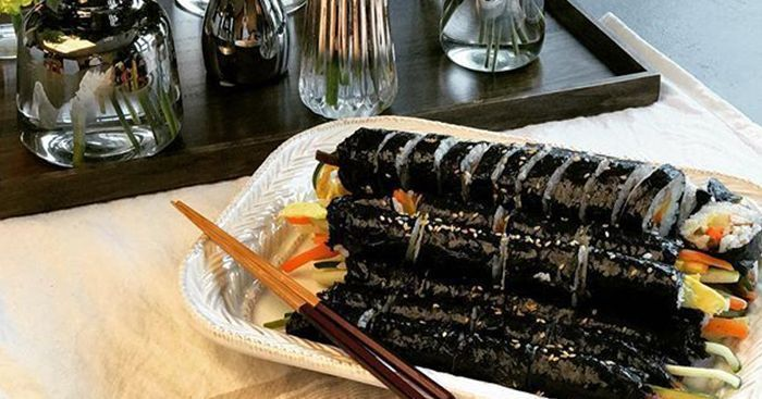 韩式传统海苔饭卷，整齐地排列在白色餐盘中，海苔包裹着多种食材。