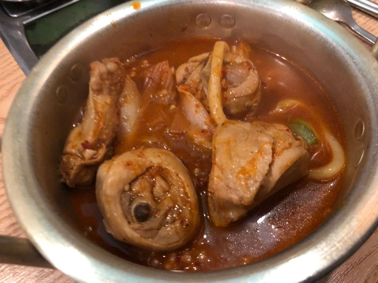 碗中盛放的安东辣炖鸡，肉块与汤汁鲜美，适合在冷天品尝。