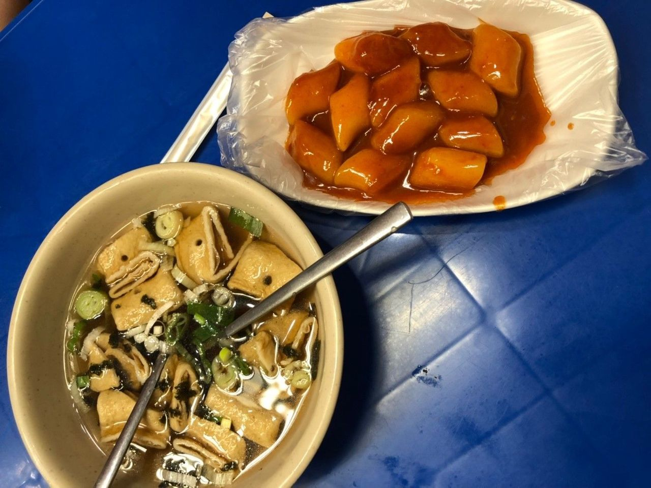 辣炒年糕与鱼豆腐汤的搭配呈现，被装盛在传统韩国青瓷的小碗中。