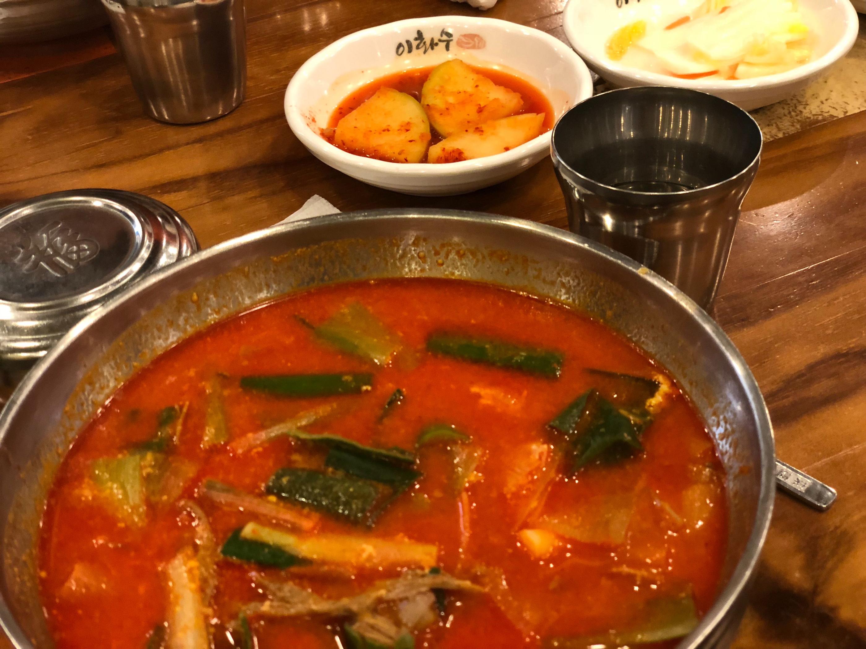 呈现温热的辣牛肉汤，搭配白饭和酱小菜，整体构成韩式传统餐点。