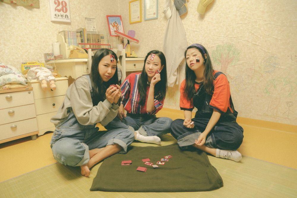 韓國山格洞照相館內，三位女性身穿90年代風格服裝，坐在復古家庭氛圍的房間內，追憶舊時光。