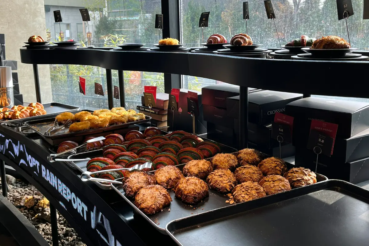 RAIN REPORT Croissantのカフェ内クロワッサンやパンのディスプレイ。窓からは自然光が射し込んでいる。