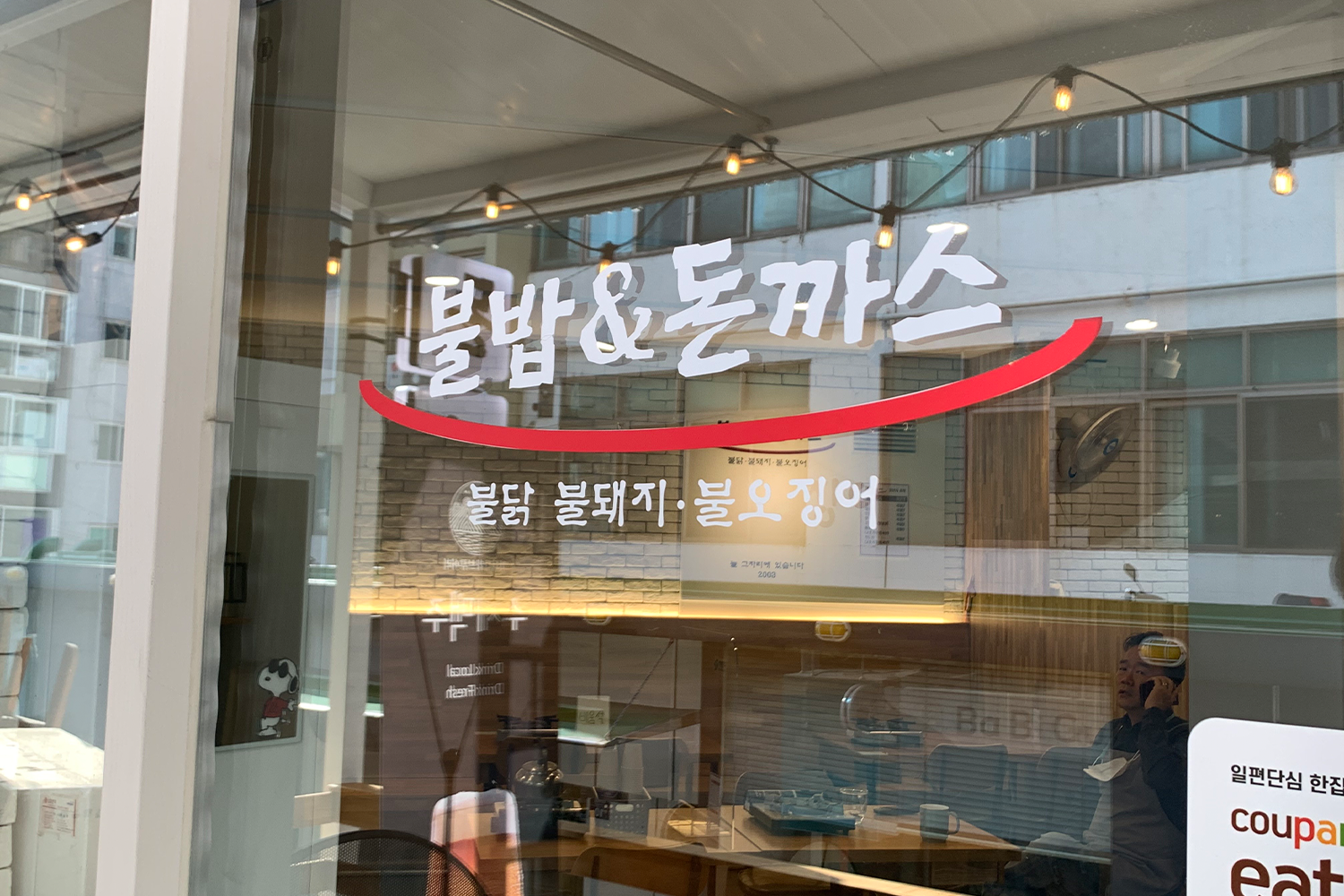 Cửa kính của nhà hàng Bulbap & Tonkatsu với logo nổi bật.