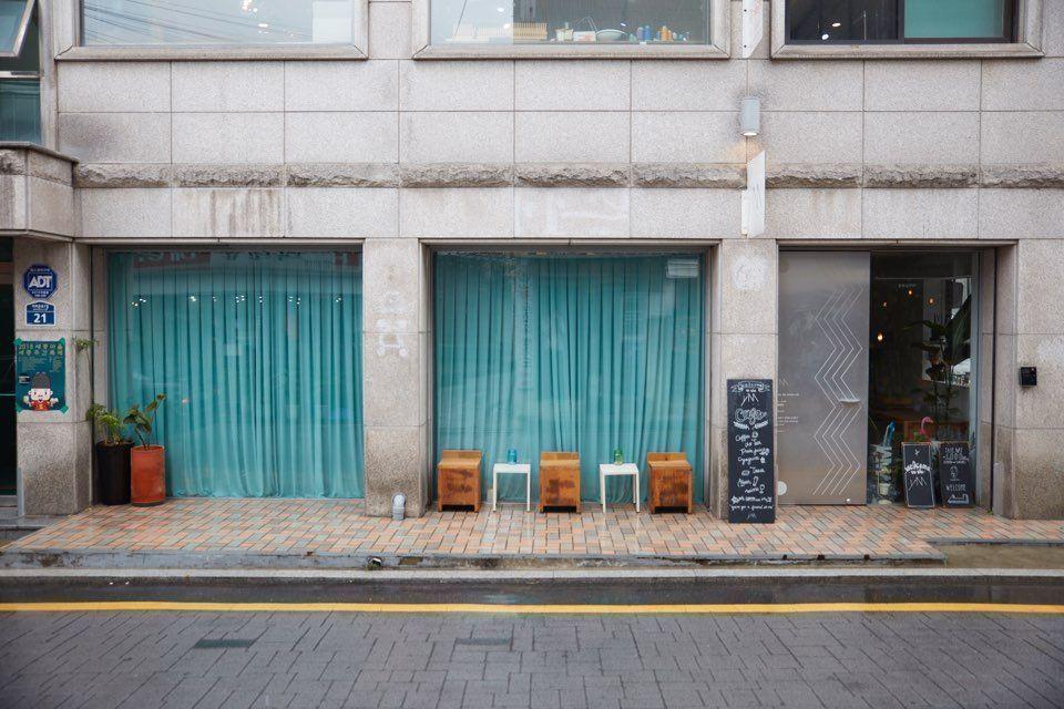 Cafe PIU 외부 전경, 창을 통해 보이는 카페 내부의 따뜻한 분위기, 경복궁 근처 인기 있는 카페 피우의 매력적인 첫인상