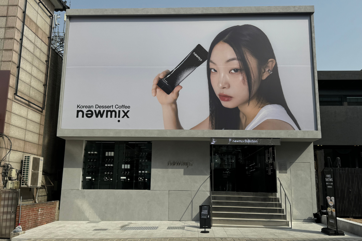 Exterior view of Newmix Coffee shop in Bukchon with grand opening sign and modern facade.