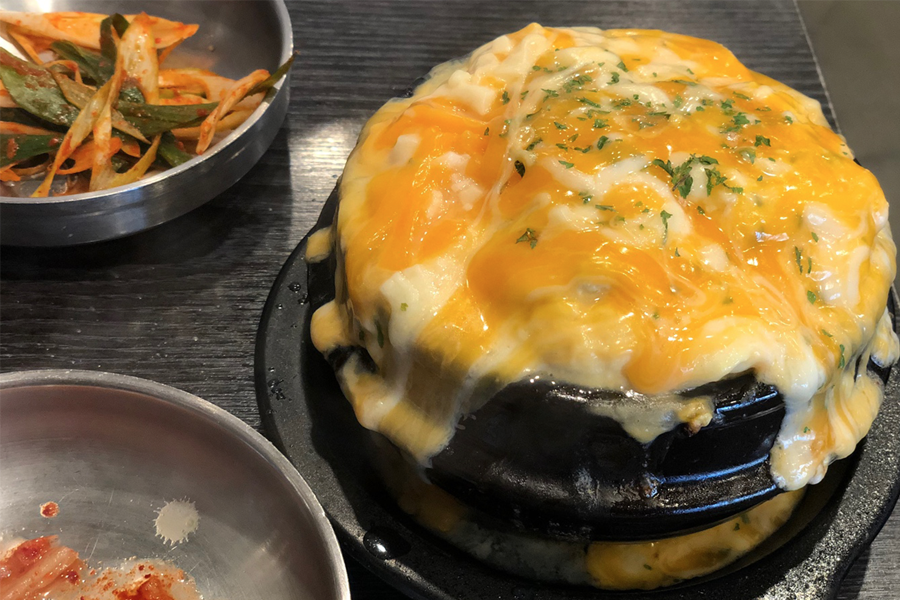 韓國弘大巨大排骨店的芝士蛋羹，上面鋪滿了融化的黃、白芝士，濃鬱誘人。