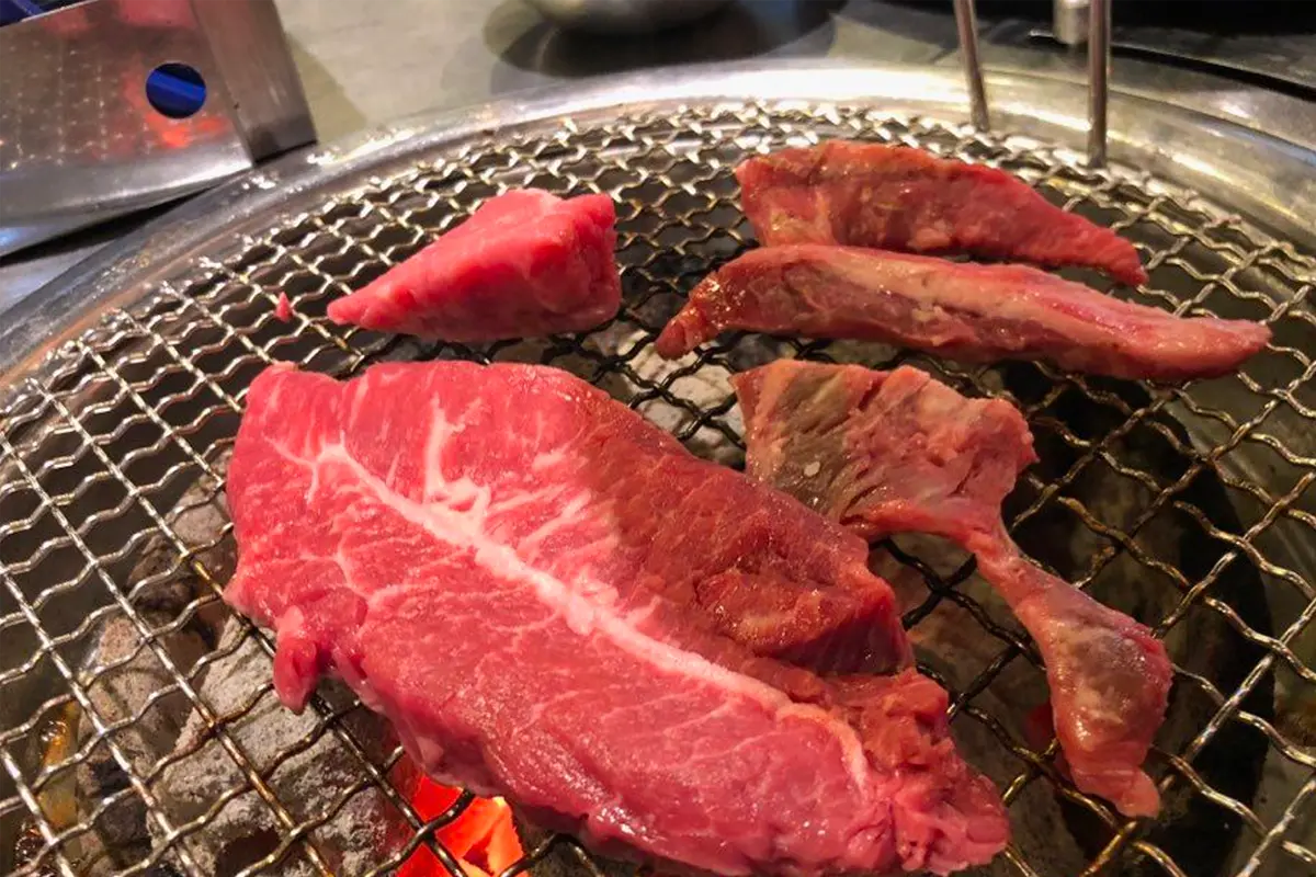 韓國無牛燒肉店的烤牛肉片在炭火上燒烤，帶有油光的牛肉看起來非常美味。