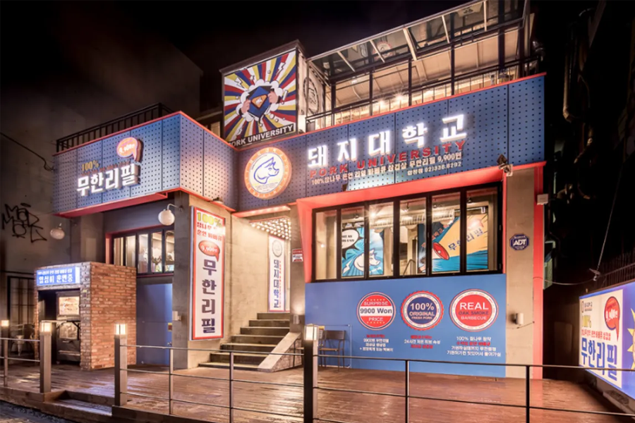 韓國豬肉大學的外部設計，夜間亮著燈光，展現出一家大學主題燒肉店的獨特風格。