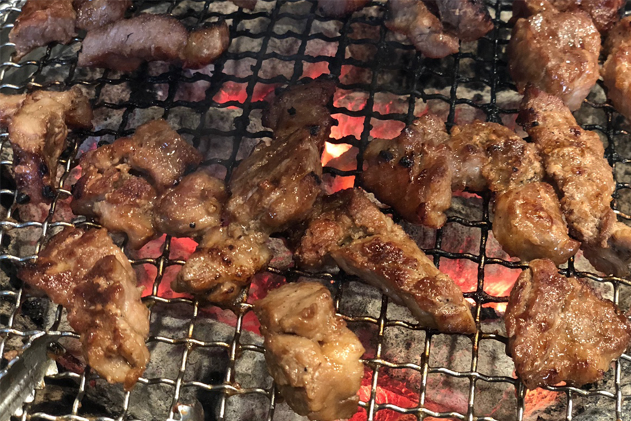韓國弘大巨大排骨店的烤排骨肉在炭火上燒烤，肉質看起來非常鮮嫩可口。