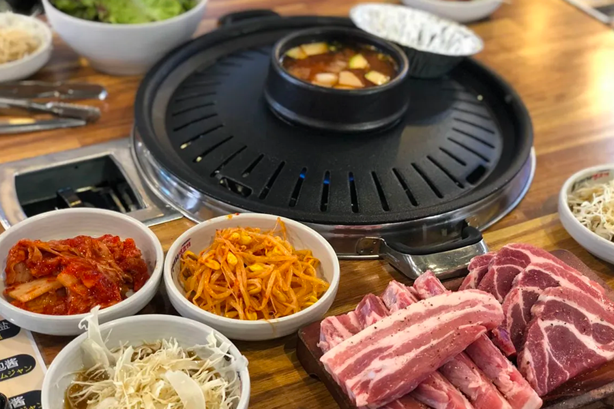 韓國弘大荒謬的生肉店內，桌上擺滿調味醬料，新鮮的豬肉正待烹製