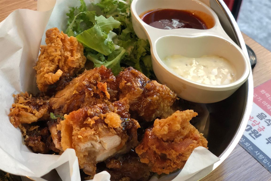 韓國弘大人氣任食燒肉店的炸雞菜餚，配有多樣調味料和沙拉。