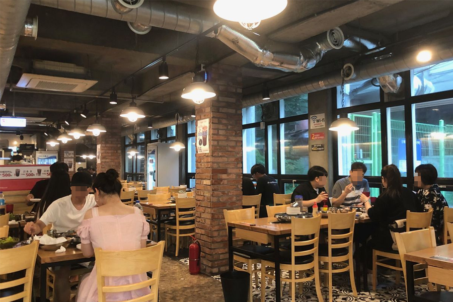 韓國弘大人氣任食燒肉店內部設計，磚牆和懸掛燈提供温馨的用餐環境。