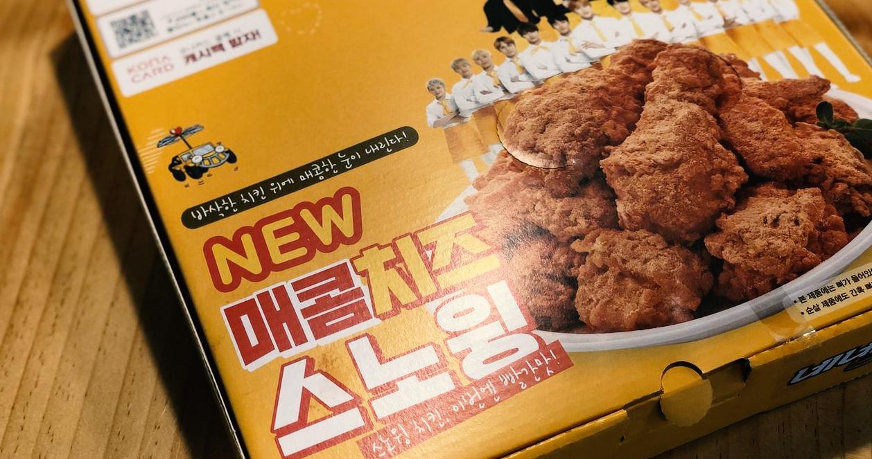 Hộp đựng gà rán cay phủ phô mai mới của NENE với thiết kế thương hiệu nổi bật.