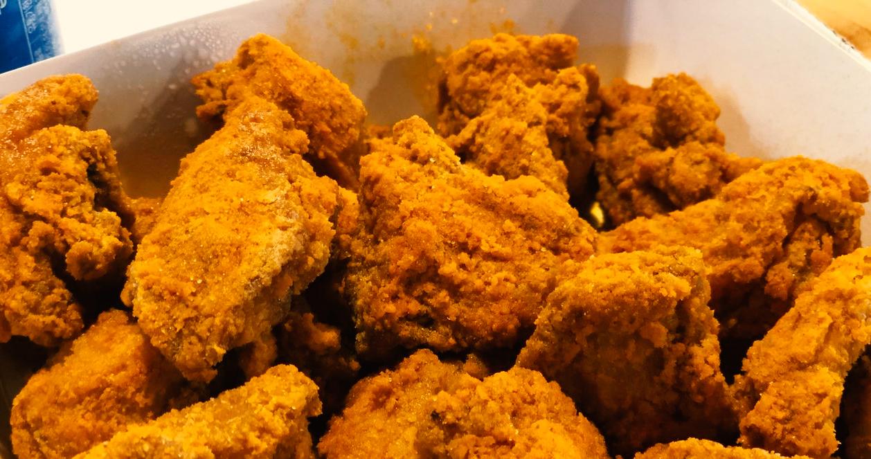 Cận cảnh gà rán cay phủ phô mai từ thương hiệu NENE với lớp phủ giòn tan.